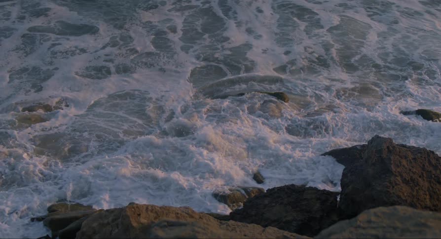 Riverbed with water moving through the rocks at sunset