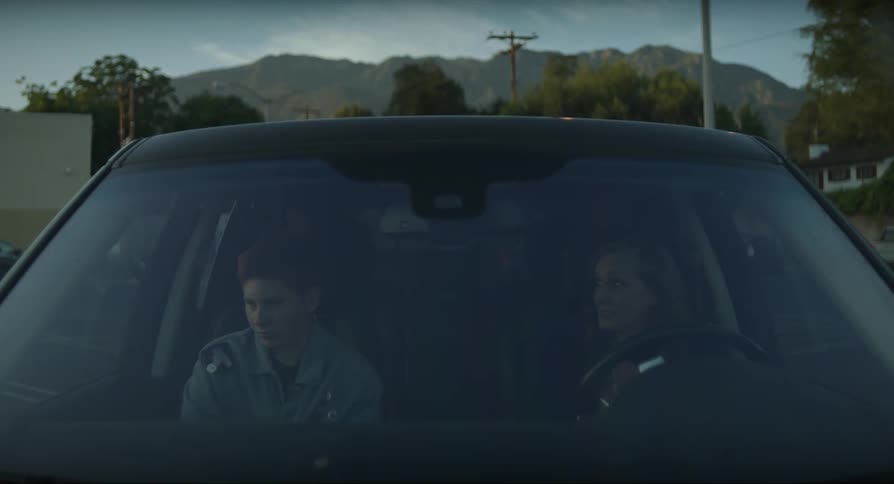 Mother have an argument with her son inside a car parked outdoors