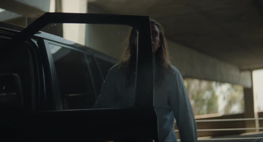 Young man looking inside the car then closing the door and looking up with a disappointed facial expression