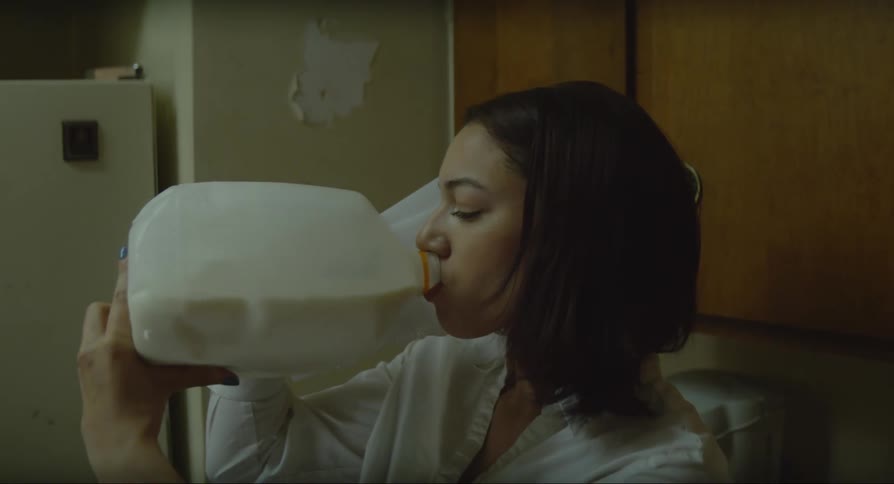 Woman opening the refrigerator taking out a carton of milk and then drinking it