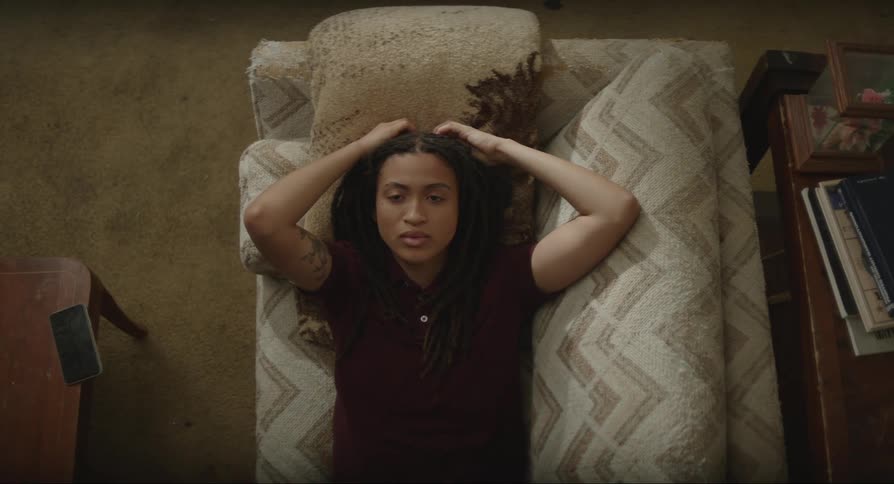 Woman lying on the sofa with her hands on her head and a discouraged facial expression