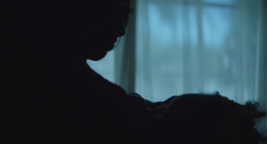 Mother standing with her baby daughter lying in her arms asleep