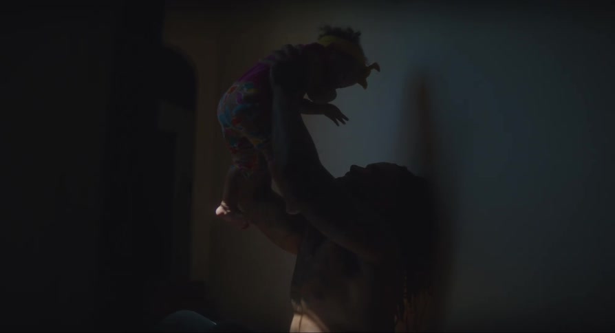 A father lifts his infant daughter into the air and brings her close for kisses