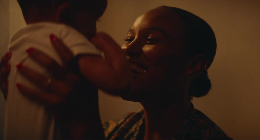 A smiling happy woman picks up and plays with a baby