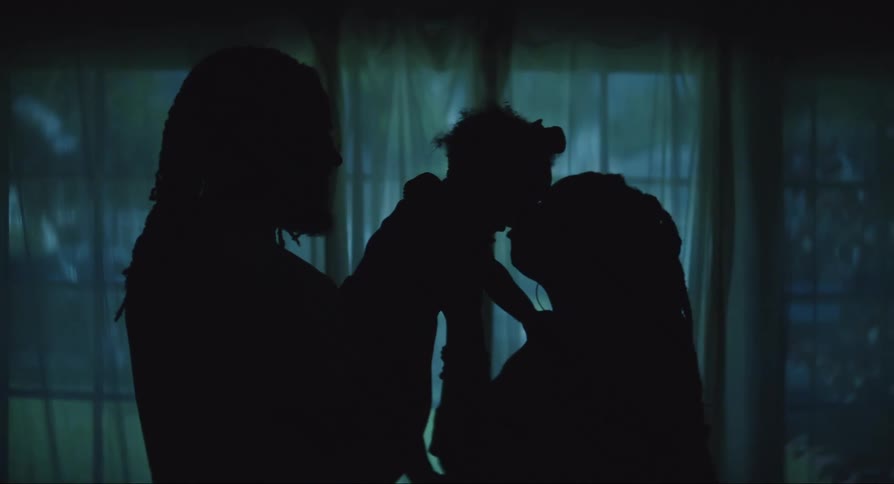 Parents hold their child and kiss her