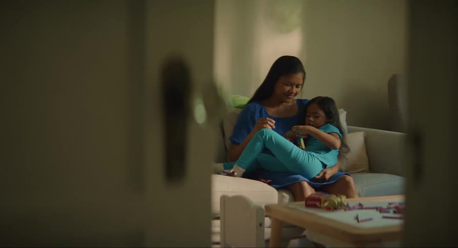 A daughter is sitting in her mothers lap