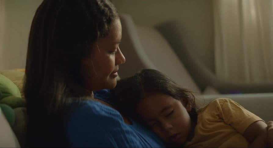 Mother sitting while her daughter sleeps in her arms