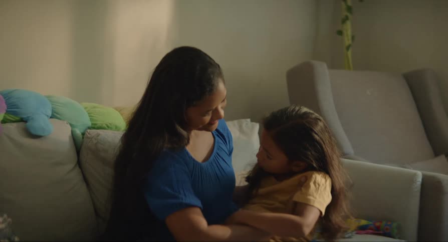 A woman with her daughter on her lap hugging her as she leans against the woman