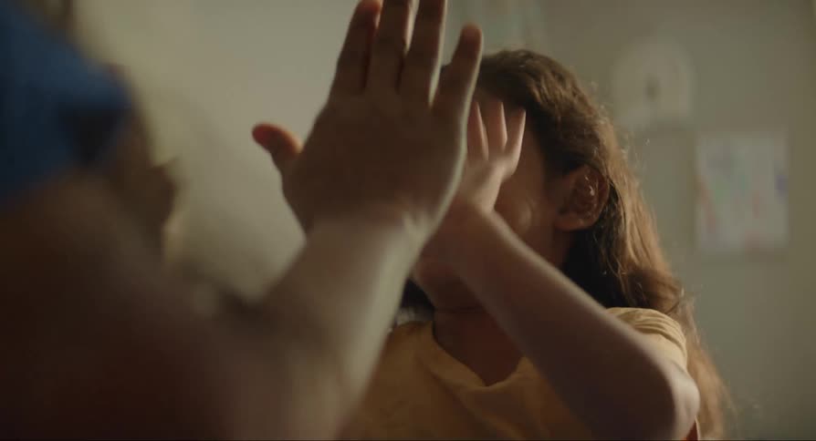 Mother playing with her daughter as they clap their hands together