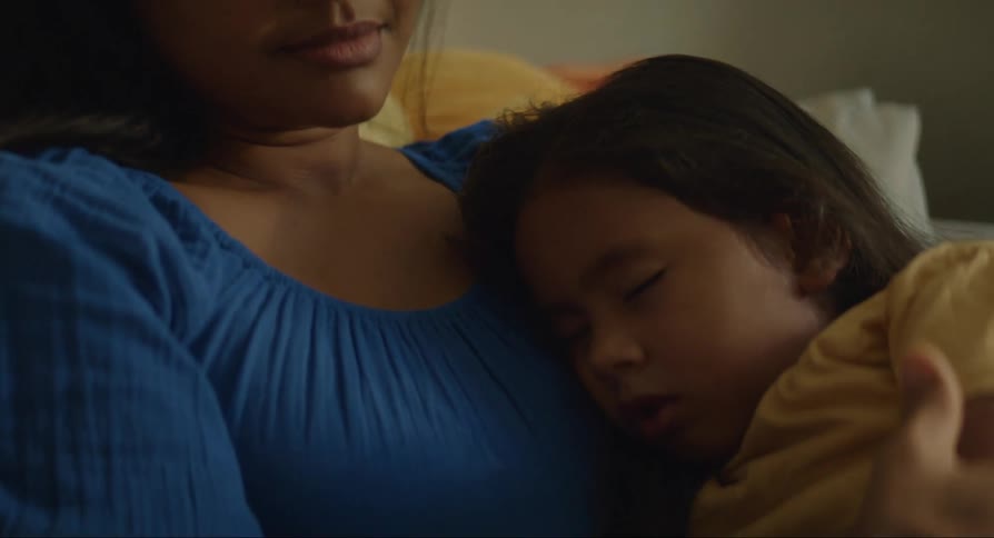 Mother sits and thinks while daughter sleeps against her