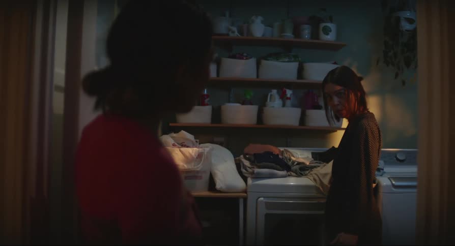 Two women talking to each other indoors at night