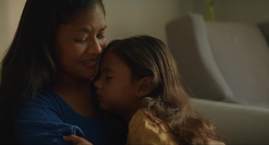 Mother sitting with her daughter in her arms as she falls asleep