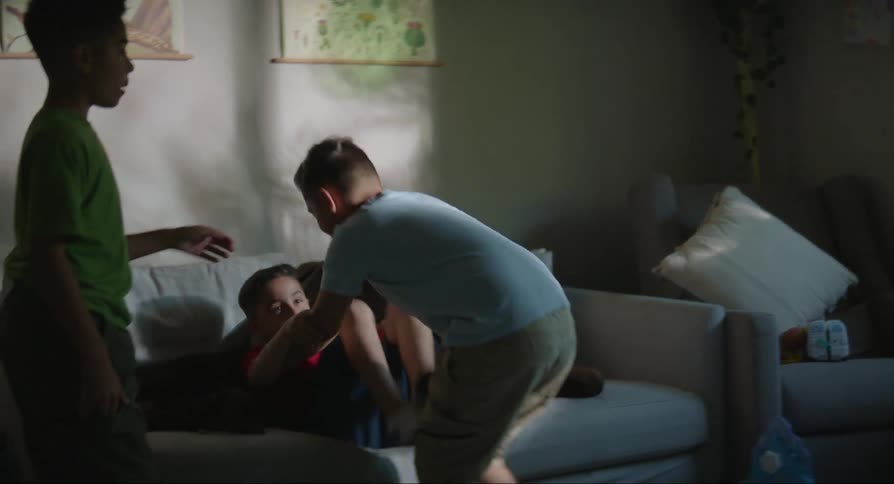 One brother protests as his brothers fight in the living room