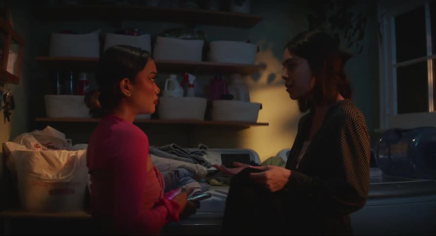 Two women are arguing while one holds a cell phone