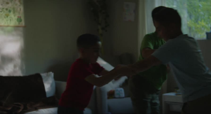 Three white boys playing in a living room indoors during day time