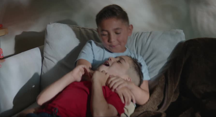 Two brothers are fighting on the couch