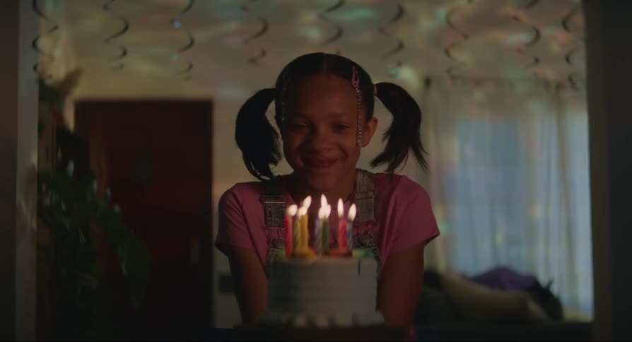 Child blowing out the candles on their birthday cake
