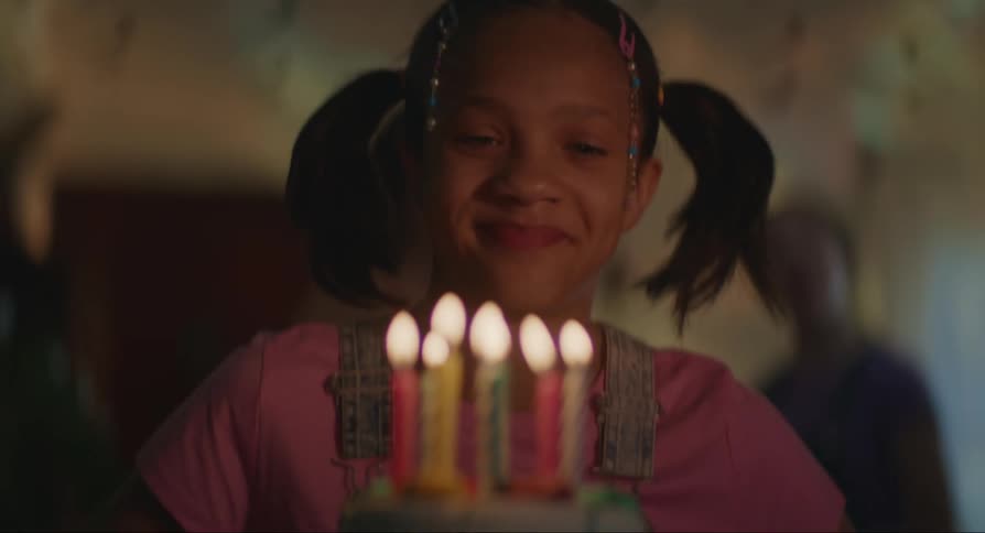 Girl blows the candles on a birthday cake