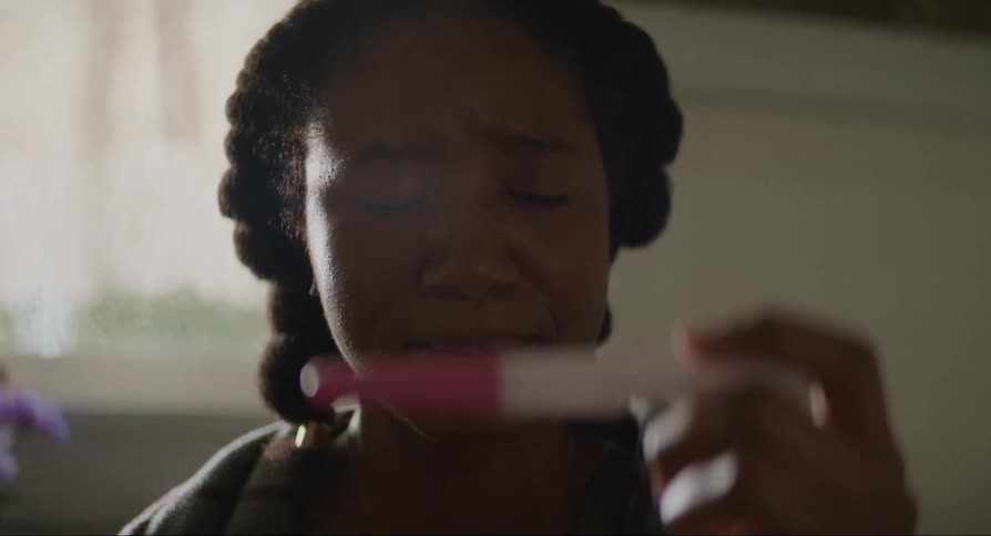 Woman cries while viewing results of home pregnancy test