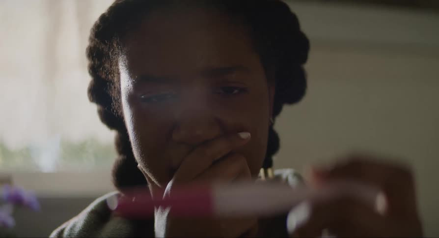 A sad woman holds a pregnancy test