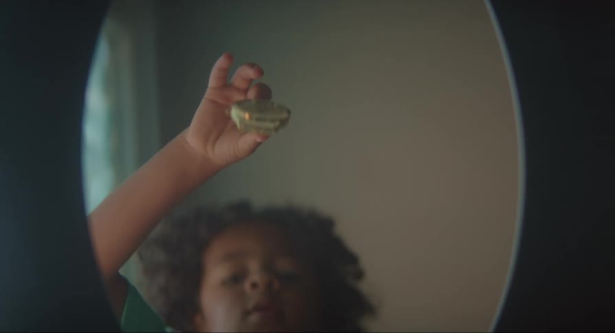 A child dangles an object over the toilet