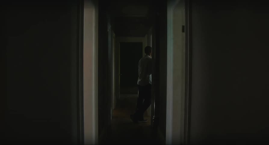 Man moves about in home hallway waiting as lights shine from outdoors