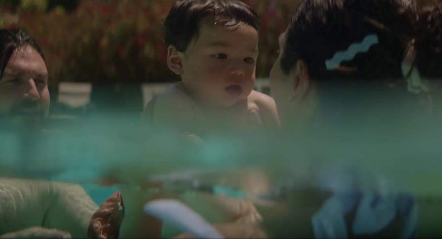 A small family enjoys the pool on a hot summer day