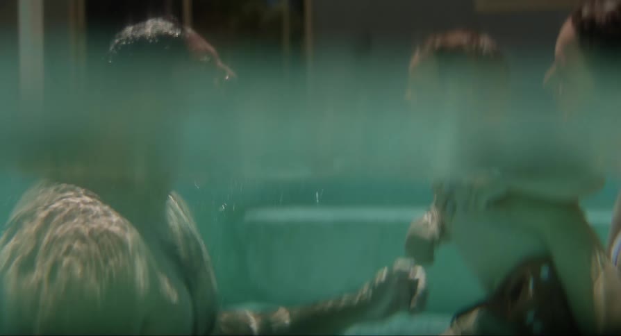 Parents play with their son in the pool