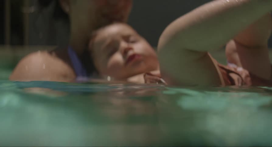 A woman with her children in her arms on top of the water
