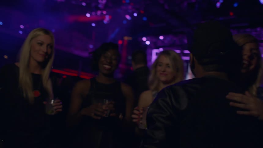 A man walks in a club and is greeted