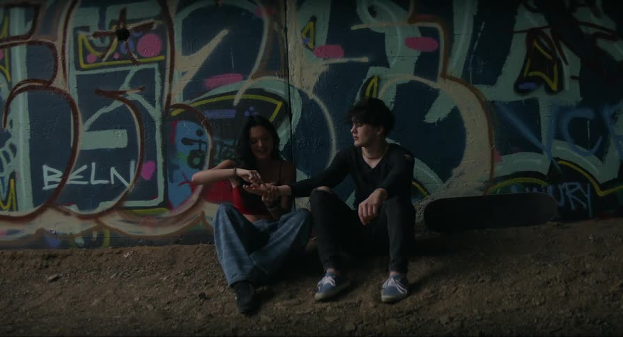 Boy and girl sitting on the floor with the boy extending his hand for the girl to play