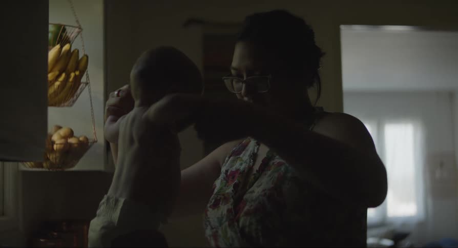 Mother in the kitchen helping her baby son balance his body