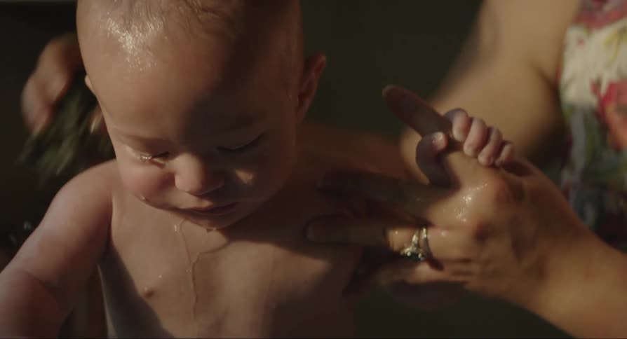 A mother is bathing her son