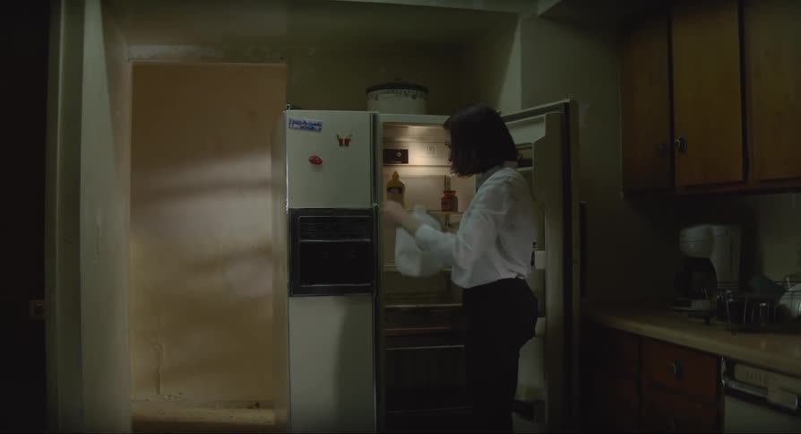 Woman opening the fridge to drink milk in the kitchen