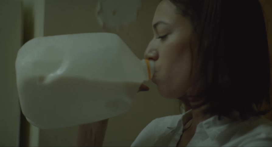 Woman taking milk from the refrigerator and drinking it afterwards