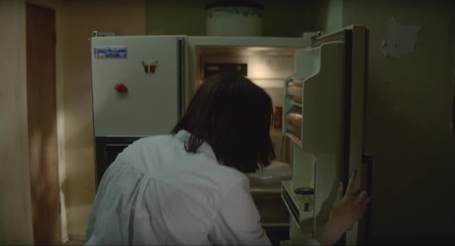 A woman comes home and smells the milk in the fridge