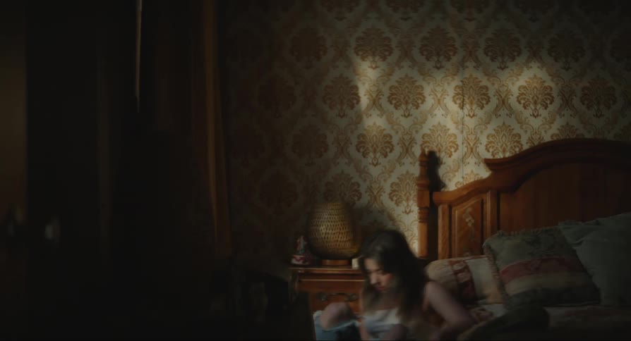 Lady walks in a bedroom looking worried and sat on the floor after checking her mobile phone