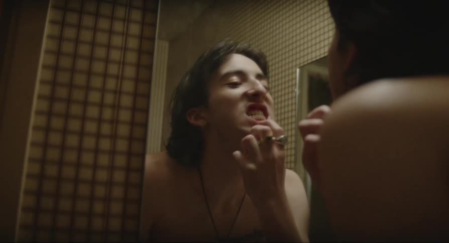 Man looking at himself in the mirror and examining his teeth