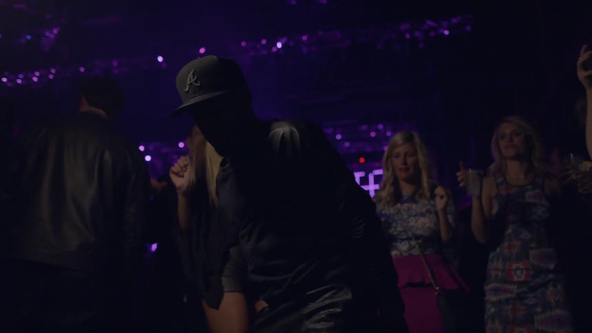 A man is dancing as others watch in a club