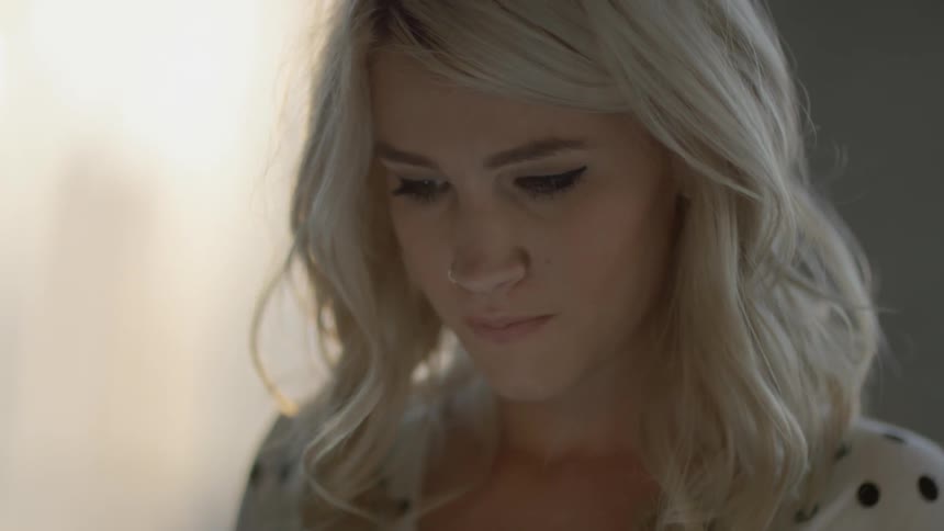 A woman with blonde hair is looking down