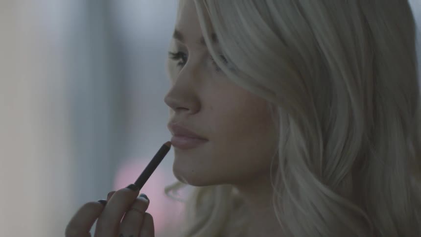 A woman is applying makeup