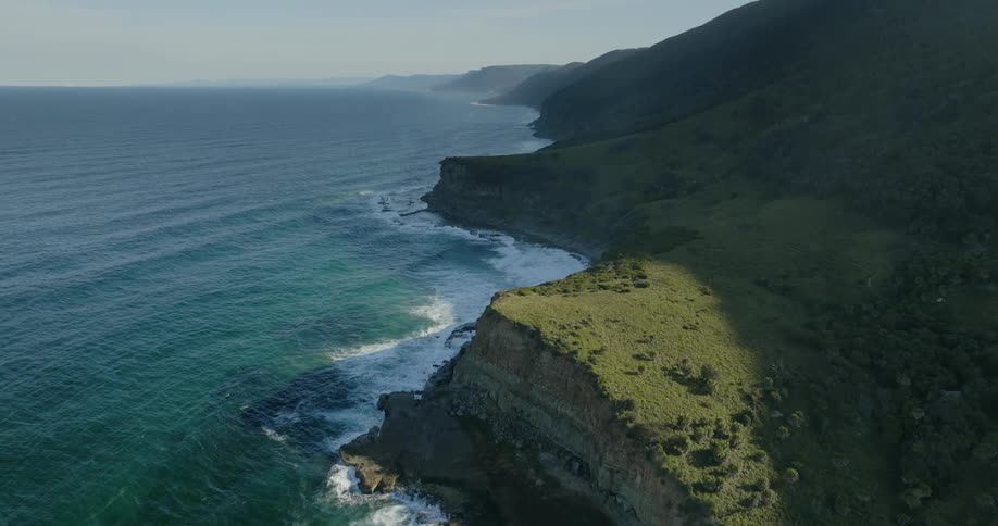 Aerial of the beach with blue water and mountains