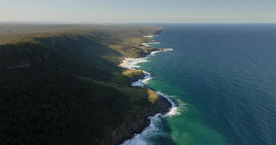 Aerial of ocean waves crashing on the shoreline at morning