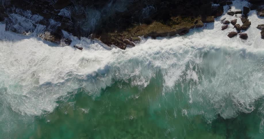 Sea waves crashing and splashing against coastal rocky formations