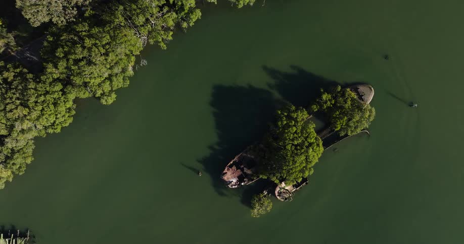 Aerial of a sunken ship on a river in the forest