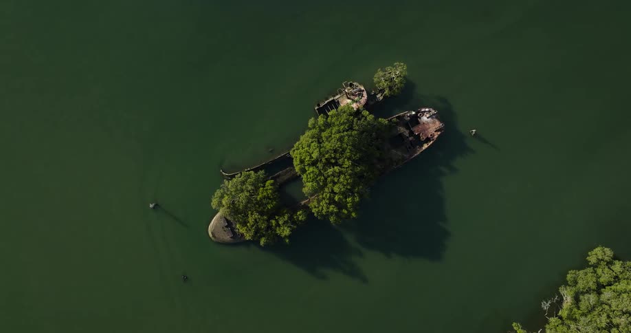 The ruins of a broken ship stranded on the slope of the water