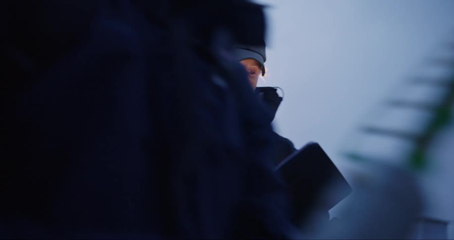 Two men in winter clothes are talking and one of them leaves while the other smiles