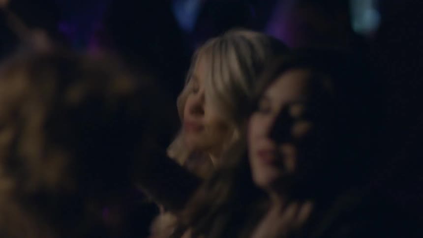 A group of women dancing while holding drinks