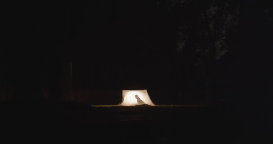 A person is in a tent in the distance