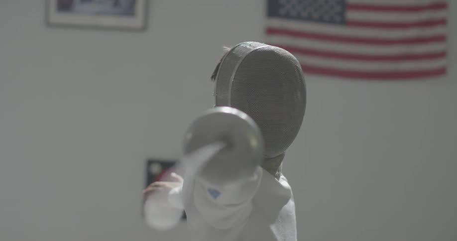 A fencer points at the camera